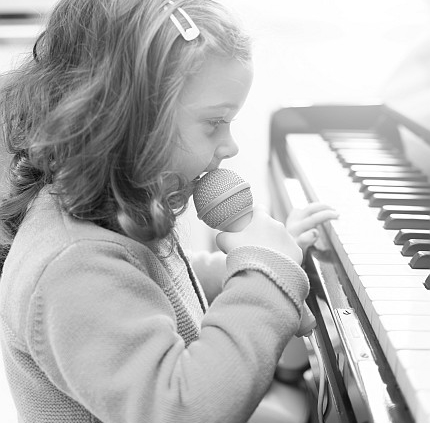 kleines-maedchen-mit-mini-keyboard-und-spielzeugmicrofon