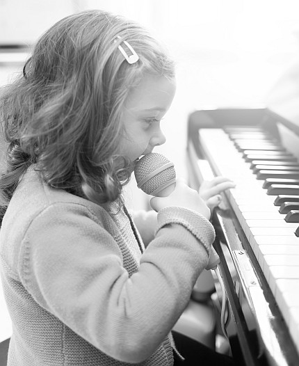 kleines-maedchen-mit-mini-keyboard-und-spielzeugmicrofon